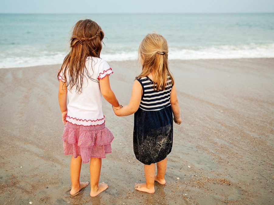 friends hold hands on the beaches of Nags Head NC