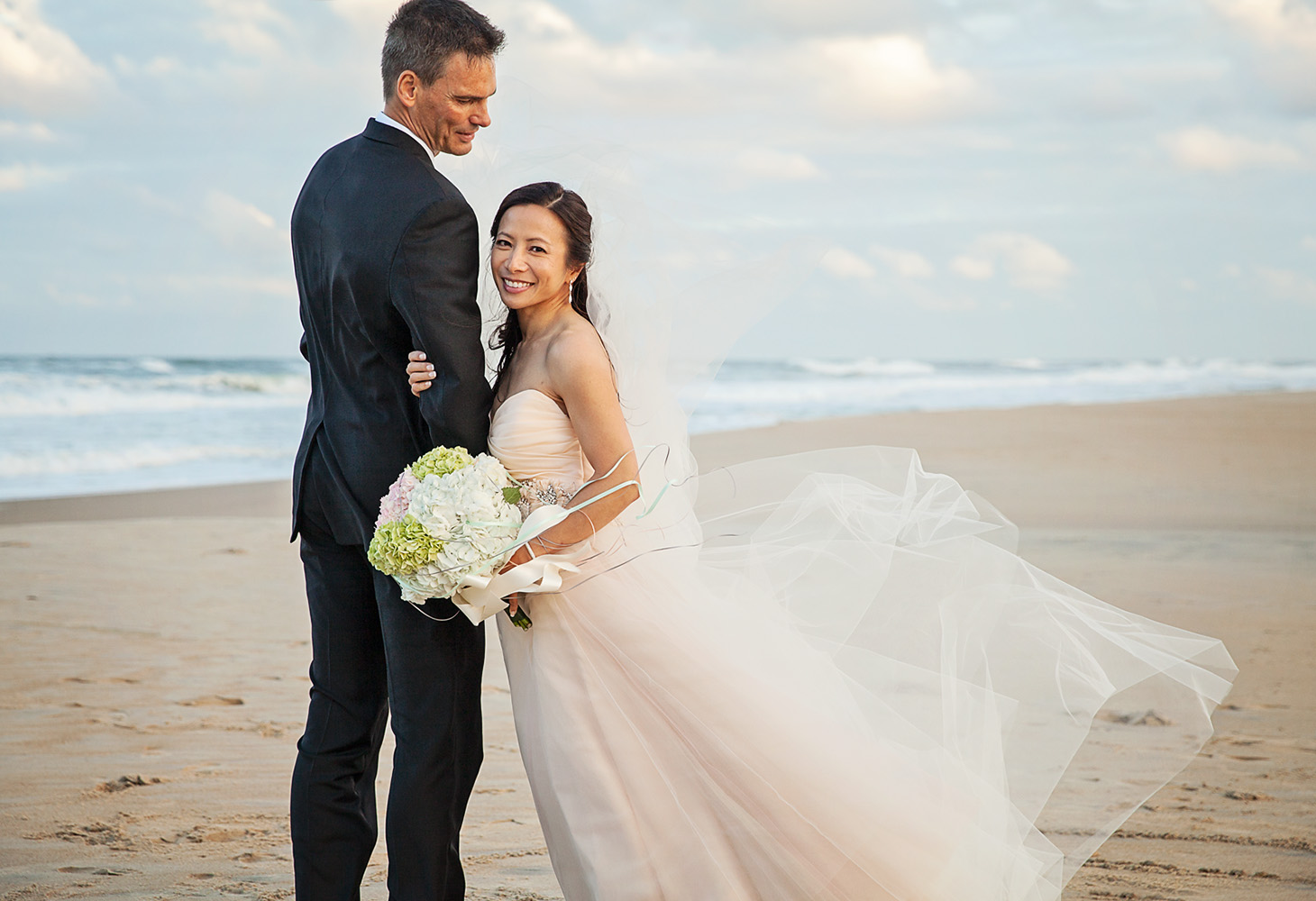 wedding couple on the beach in nags head with amazing dress